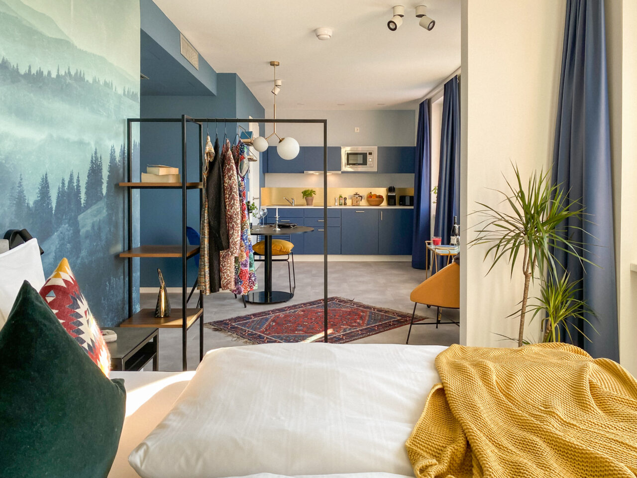 Bett vor einem Wandbild mit Waldlandschaft